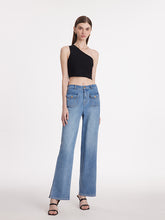 A lady wears a crop top and jeans.